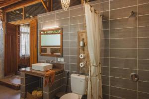 a bathroom with a toilet and a sink and a mirror at Resort JUNGLEROOM Canggu in Canggu +226 photos