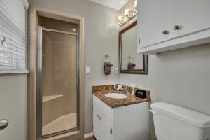 Un baño con inodoro, lavabo y ducha. en Cora Street Cottage, en Fredericksburg 17 fotos más