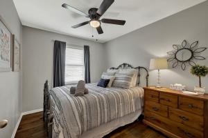 1 dormitorio con 1 cama con ventilador de techo y vestidor en Cora Street Cottage, en Fredericksburg