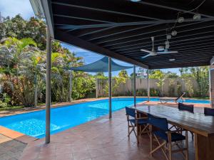 an open patio with a table and a swimming pool at Bilikiki Hideaway in Honiara