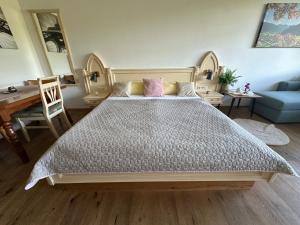 a bedroom with a large bed and a blue couch at Steinbock Apartement in Bad Goisern