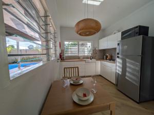 a kitchen with a wooden table and a refrigerator at Bilikiki Hideaway in Honiara
