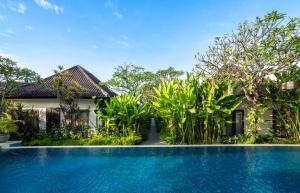 a swimming pool in front of a villa at Rama Residence Petitenget in Seminyak