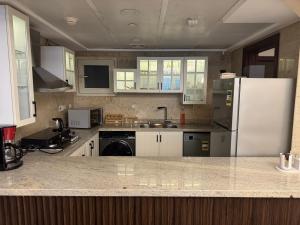 a kitchen with white cabinets and a white refrigerator at شقه فندقيه نيل هلتون ريزيدنس المعادي in Cairo