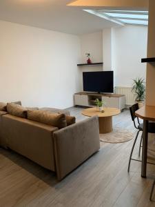 a living room with a couch and a tv at Apartmán Centrum in Šamorín
