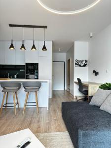 Una sala de estar con un sofá y una cocina. en Hi Park Apartment, Free Parking, en Bratislava
