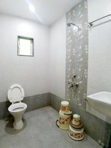 a bathroom with a toilet and a sink and a shower at Hotel Sai SK Palace in Shirdi +18 photos