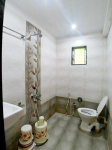 a bathroom with a toilet and a tub and a sink at Hotel Sai SK Palace in Shirdi