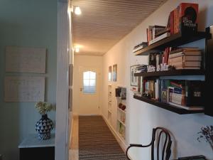 a hallway with bookshelves and a table and a chair at Kaunas Inn Colors in Kaunas