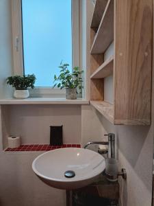 a white sink in a bathroom with a window at Kaunas Inn Colors in Kaunas