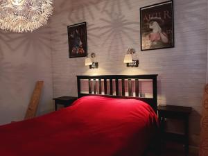 a bedroom with a red bed and a chandelier at Kaunas Inn Colors in Kaunas