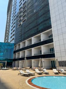 a large building with a pool and chairs and umbrellas at شقه فندقيه نيل هلتون ريزيدنس المعادي in Cairo