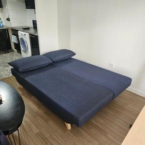 - un lit avec des draps bleus dans une chambre dans l'établissement Appartement Cormeilles, à Cormeilles-en-Parisis