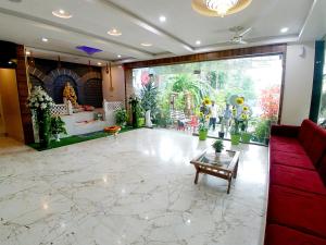 a lobby with a red couch and a large window at Hotel Sai SK Palace in Shirdi