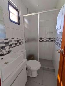 a white bathroom with a toilet and a shower at Casa Benito Resort 