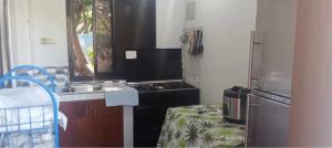 a kitchen with a stove and a sink and a refrigerator at Casa Benito Resort in Sauay
