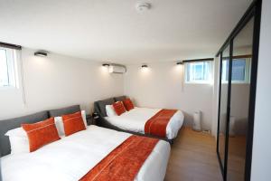 two beds in a small room with windows at amairo Villa in Asahikawa