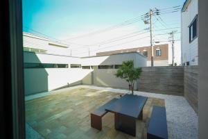 a patio with a black table and a tree at amairo Villa in Asahikawa