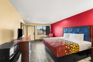 a hotel room with a bed and a flat screen tv at Econo Lodge Belton in Belton +20 photos
