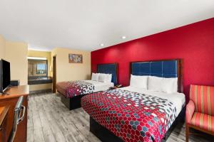 a hotel room with two beds and a red wall at Econo Lodge in Belton