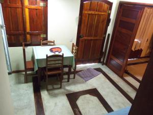 een eetkamer met een tafel en stoelen en houten deuren bij Sobrado Paraty in Paraty