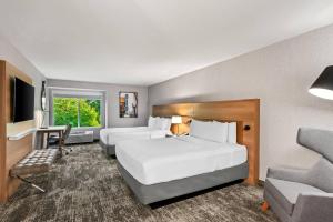 a hotel room with two beds and a chair at Radisson Hotel Portland Airport in Portland