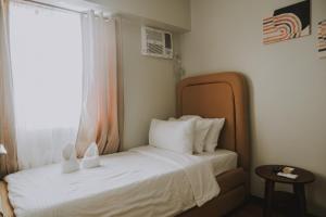 a bedroom with a bed with white sheets and a window at Casa Palma at Verdon Parc in Davao City +25 photos