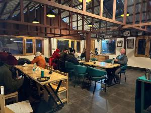 a group of people sitting at tables in a restaurant at Escape Adventure Camps By Escape Stays, Luxury Swiss Camps by Glacier water Stream, Complimentary Bonfire, Travelers Award winner from Last 4 Years in Saturang