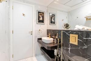 a bathroom with a sink and a black marble counter at Dubai Luxury 1BR Apartment Lagoon View Near Miracle Garden Pool Spa by Green Sky Holiday Homes in Dubai