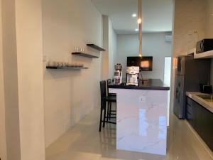 a kitchen with a counter with a bar in it at Klissy Studio Villa in Kerobokan