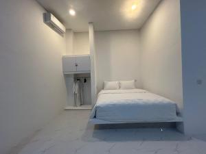 a white bedroom with a bed and a white wall at Klissy Studio Villa in Kerobokan