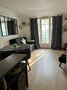una sala de estar con un sofá y una mesa en La Perle des Pins, en Lacanau