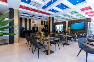 jadalnia ze stołami i krzesłami oraz telewizorem z płaskim ekranem w obiekcie HH Riz Resort - Adults Only w mieście Maspalomas