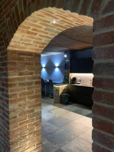 a brick archway in a room with a kitchen at Villa Corleone in Nizza Monferrato