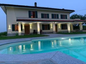 a house with a swimming pool in front of it at Villa Corleone in Nizza Monferrato