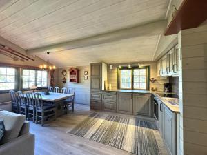 a kitchen and dining room with a table and chairs at Briskebu, cosy cabin by ski slopes in Geilo +12 photos