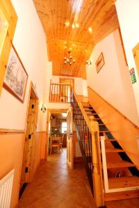 a staircase in a house with a wooden ceiling at Beezies Self Catering Cottages in Grange