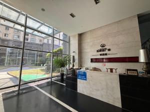 a lobby with a reception desk and a large window at Shanghai Serviced Apartments in Shanghai