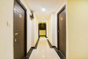 a hallway with two sets of doors and a walkway at Super Collection O City Center New Town Kolkata Formerly Paradise Inn in Salua
