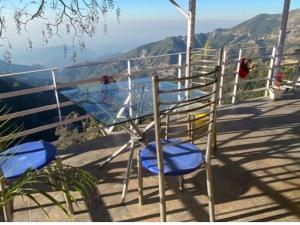 two blue chairs sitting on top of a balcony at Aagman Homestay & Rooftop Restaurant in Mussoorie