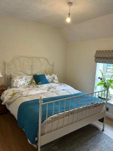 una camera da letto con un letto con lenzuola blu e una finestra di The Hollow a Laois