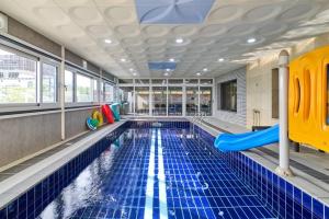 a swimming pool with a slide in a building at Daebudo DuMong DalGeum Pool Villa in Ansan
