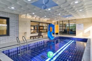 a swimming pool with a slide in the middle at Daebudo DuMong DalGeum Pool Villa in Ansan