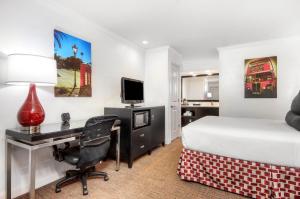 a hotel room with a bed and a desk with a computer at Aggie Inn, an Ascend Collection Hotel in Davis