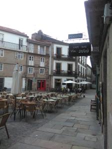 una calle vacía con mesas, sillas y edificios en Pension Via-Stella, en Santiago de Compostela