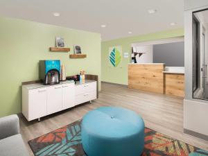 a waiting room with a blue ottoman in a room at WoodSpring Suites Charlotte Airport in Charlotte
