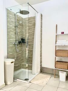 a shower with a glass door in a bathroom at Urban Nest - Paris - CDG - Parking & Confort in Pavillons-sous-Bois +16 photos