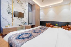 a bedroom with a large bed and a television at Hotel Abhi international in Pathānkot
