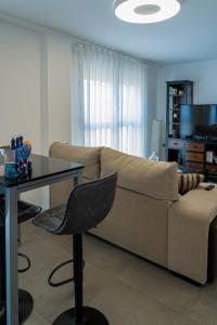 a living room with a couch and a table at Piso-loft AOVE pleno centro in Jaén +19 photos