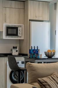 a kitchen with a microwave and a table with a chair at Piso-loft AOVE pleno centro in Jaén